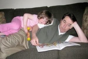 girl and dad reading together