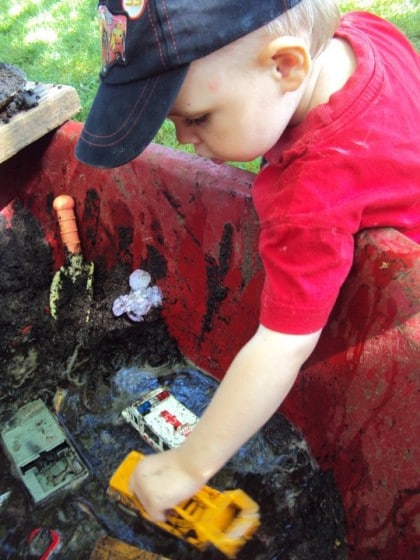 Child playing with cars in mobile mud patch