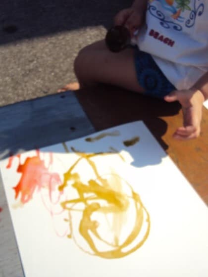 Child making art with coloured ice