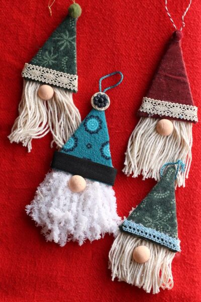 4 gnome ornaments on red background