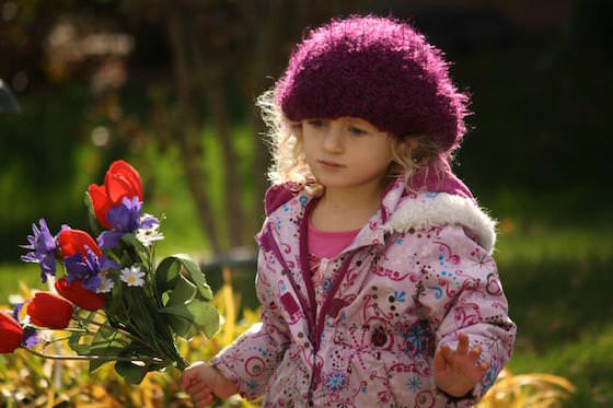 preschooler carrying flowers in sunshine