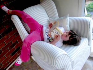 girl sprawled upside down in a chair reading BFG