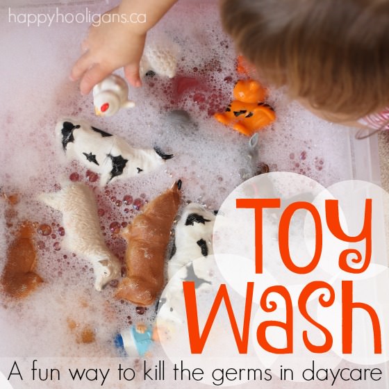 Preschooler washing plastic toys in bin of soap and water