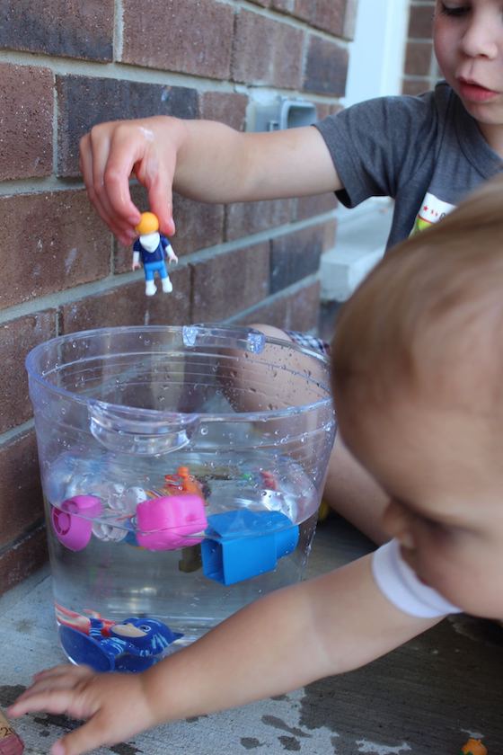 child adding toy to water for sink or float activity