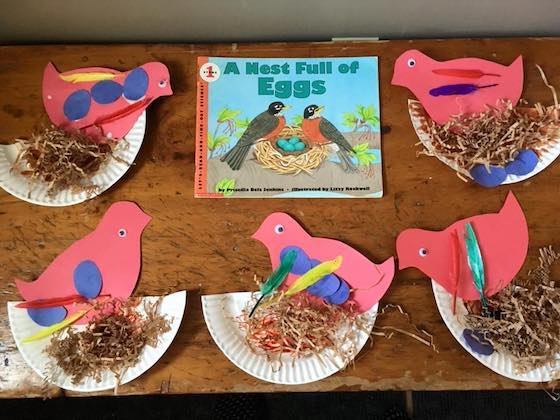 construction paper birds and nests beside preschool bird book