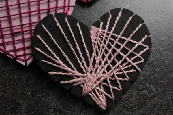 black cardboard heart with pink string
