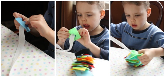 Child developing his fine motor skills by threading felt squares onto button snake.