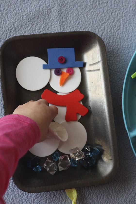 child building snowman with craft supplies