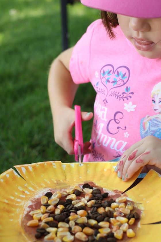 child cutting paper plate