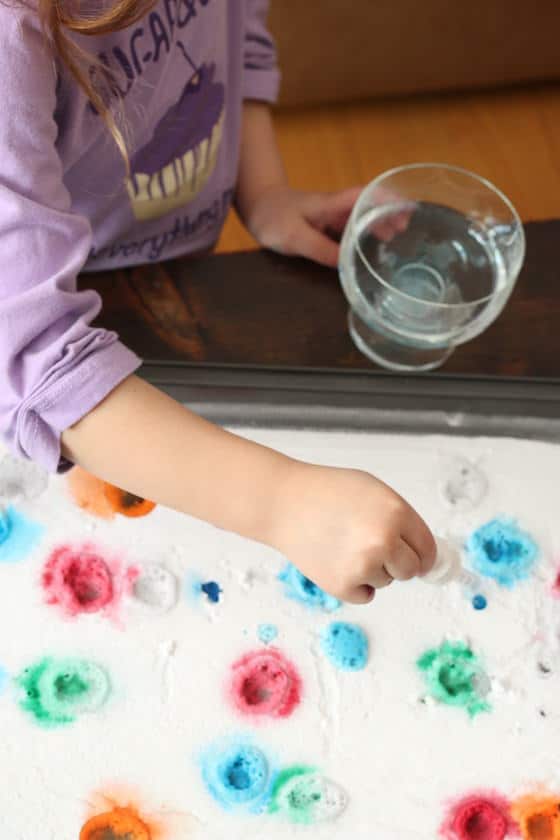 child dripping vinegar on baking soda