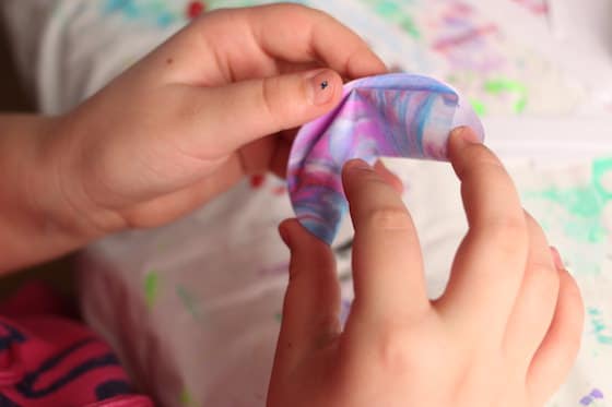 Child folding paper fortune cookie