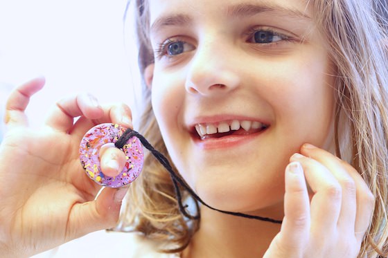 child holding painted washer necklace