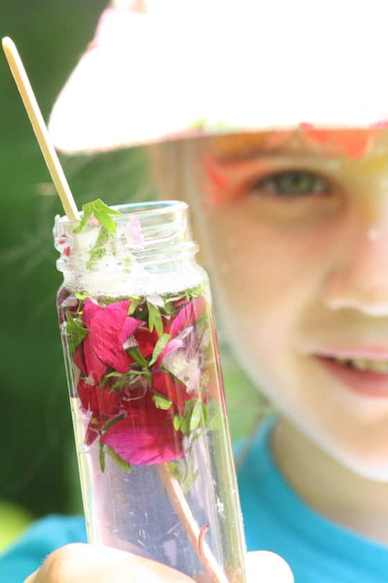 child holding up bottle of homemade perfume