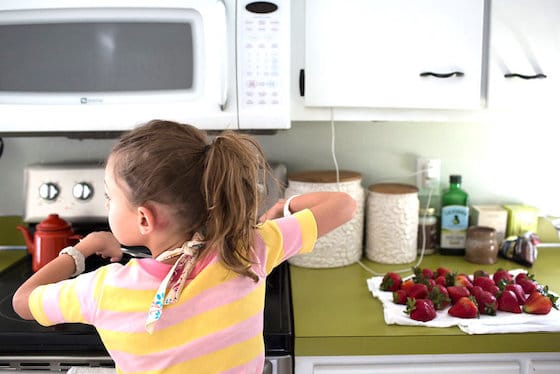 child melting chocolate in pot on stove