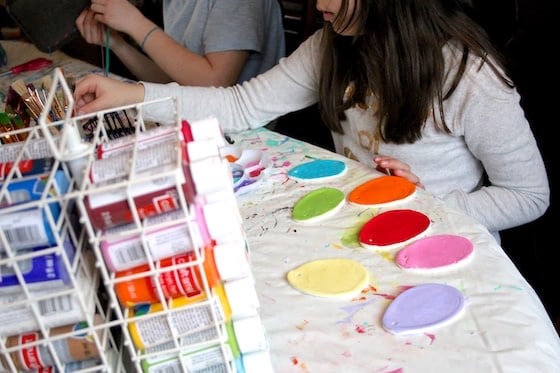 Child painting clay dough eggs with acrylic paint