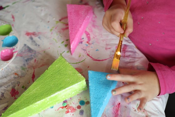 child painting styrofoam trees