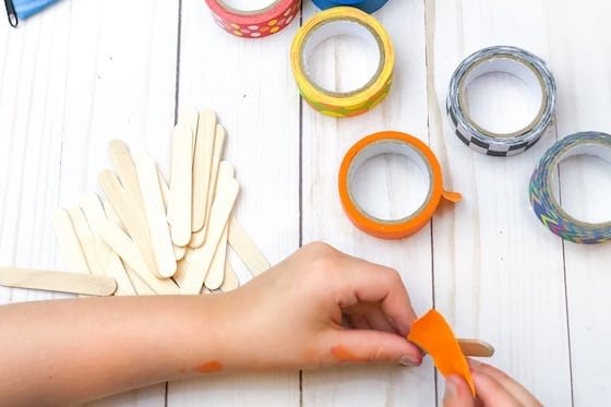 Child taping craft stick