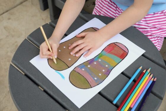 child colouring cardboard shoe