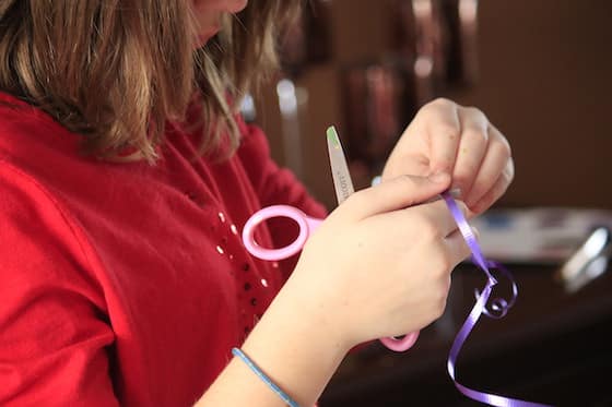 Child twirling ribbon with pair of scissors