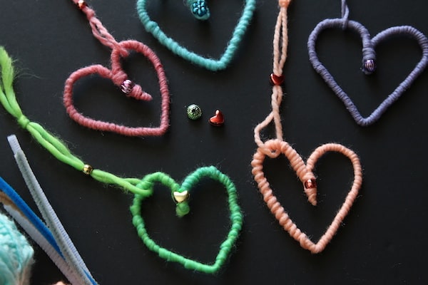 close up heart ornaments made with pipe cleaners wrapped with yarn