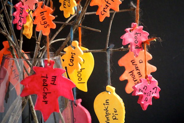 painted clay leaves hung on branches in vase