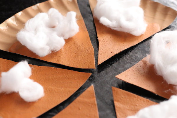 close up pumpkin pie with puffy paint filling and cotton ball whipped cream