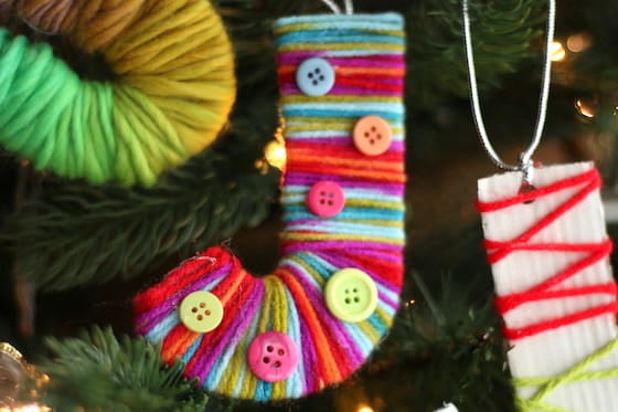 Cardboard letter J wrapped with colourful yarn and decorated with buttons