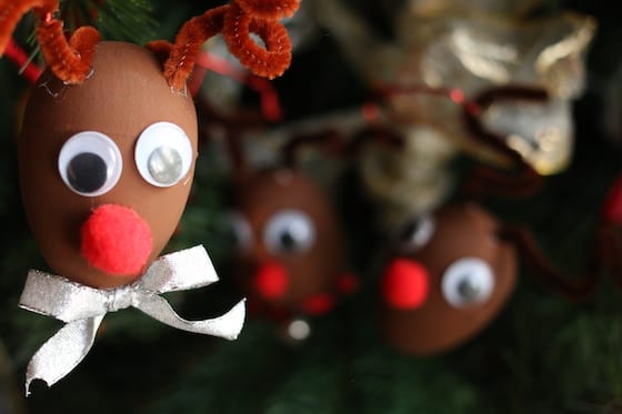 Close up of plastic egg reindeer on Christmas tree with 2 reindeer in background