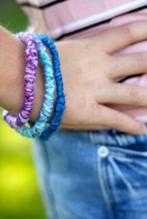 teen wearing yarn wrapped pipe cleaner bracelets, hand on hip