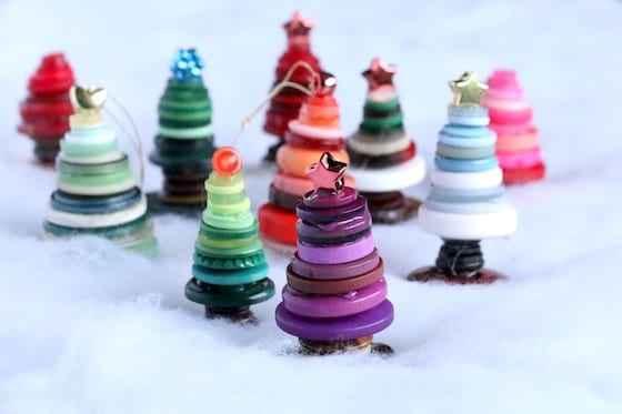 Colourful button Christmas trees standing on bed of white quilt batting