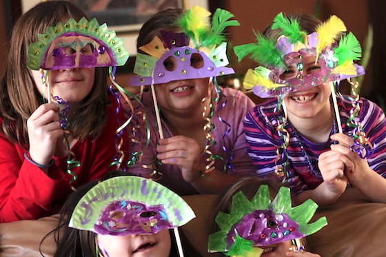 daycare kids holding up homemade mardi gras masks