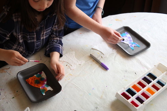 kids dripping liquid watercolours on paper towels