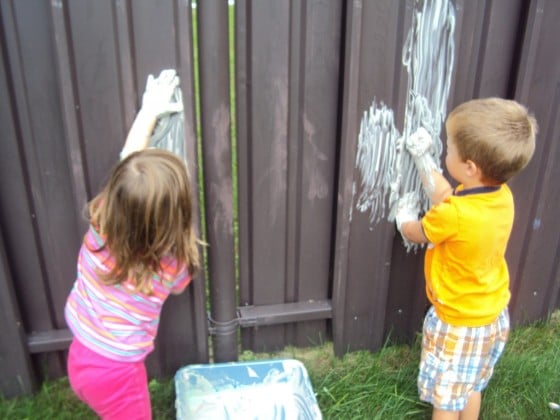 kids painting on fence with shaving cream