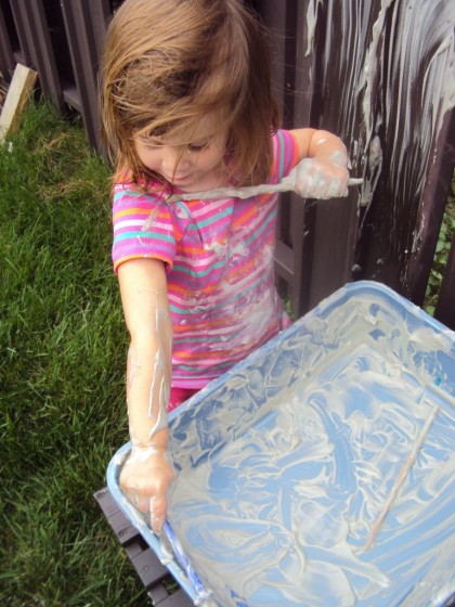 toddler painting arm with shaving cream 