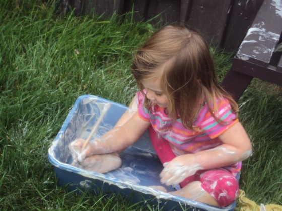 Child playing in bin of shaving cream