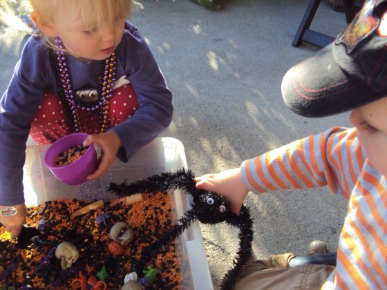 a bin of black and orange lentils for halloween sensory play