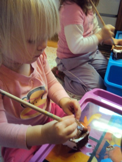 kids painting gingerbread house ornaments