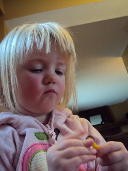 toddler threading cheerios on pipe cleaner