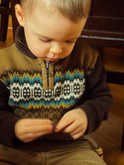 toddler boy putting cheerios on pipe cleaner