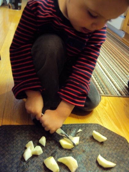 preschooler cutting apples with butter knife