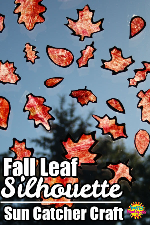 Fall Leaf Silhouettes with painted orange wax paper illuminated by sunshine in window
