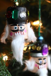 2 cork nutcracker heads on christmas tree, bokeh lights background