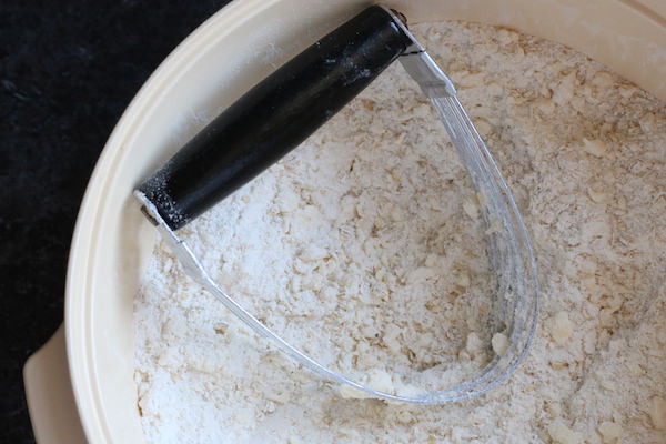 pastry cutter cutting flour, quick oats
 and butter