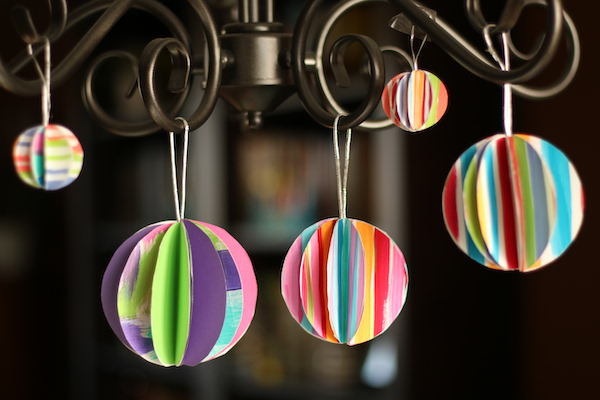 folded paper ornaments hanging from chandelier