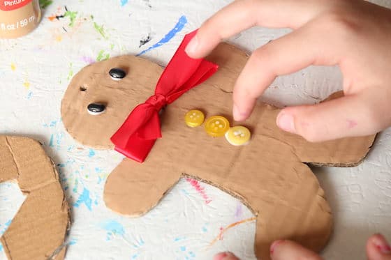 gluing buttons on gingerbread man