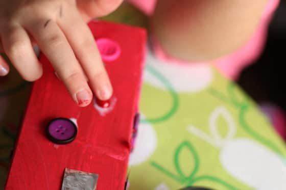 gluing decorative beads on red milk carton