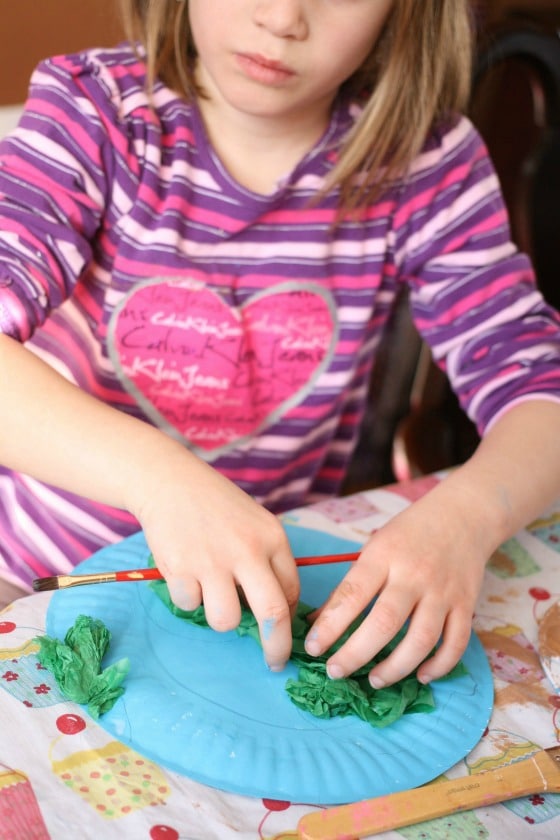 gluing green tissue paper on blue paper plate 2