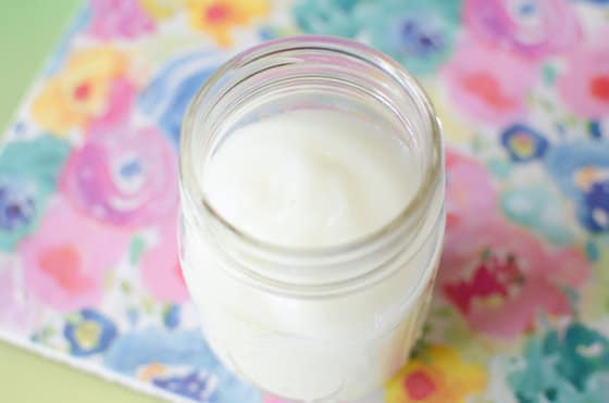 glass jar filled with homemade glue on flowered paper backdrop