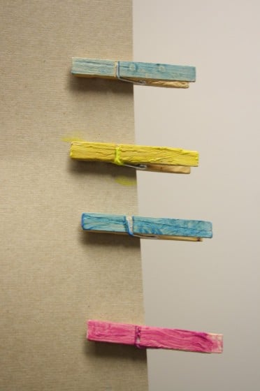 painted clothespins pinned to piece of cardboard