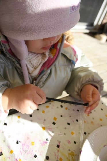 toddler painting glue on plastic icicle